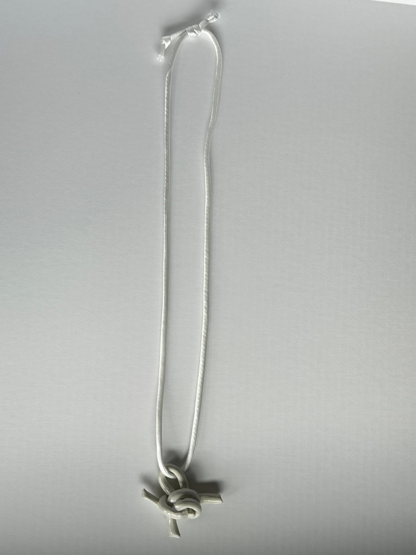 Ceramic knot pendant with silk cord in white