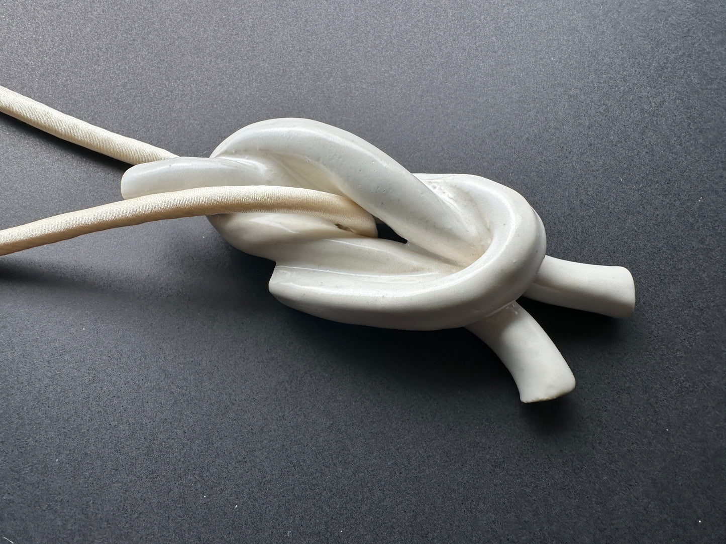 Ceramic knot pendant with ivory silk cord